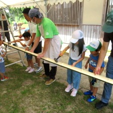 竹の樋を使った流しそうめんの準備をする子どもたちとスタッフ