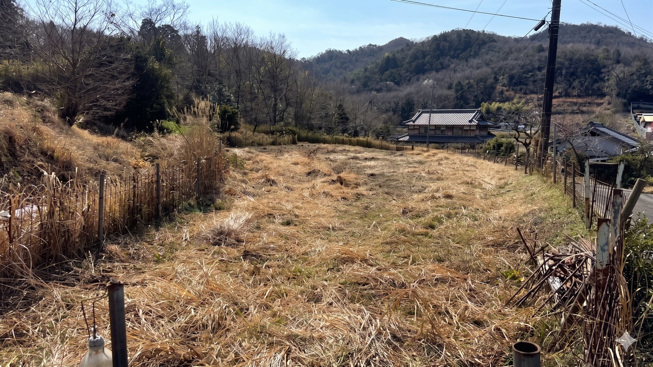 草刈り後に広がる耕作放棄地と西谷の山の風景