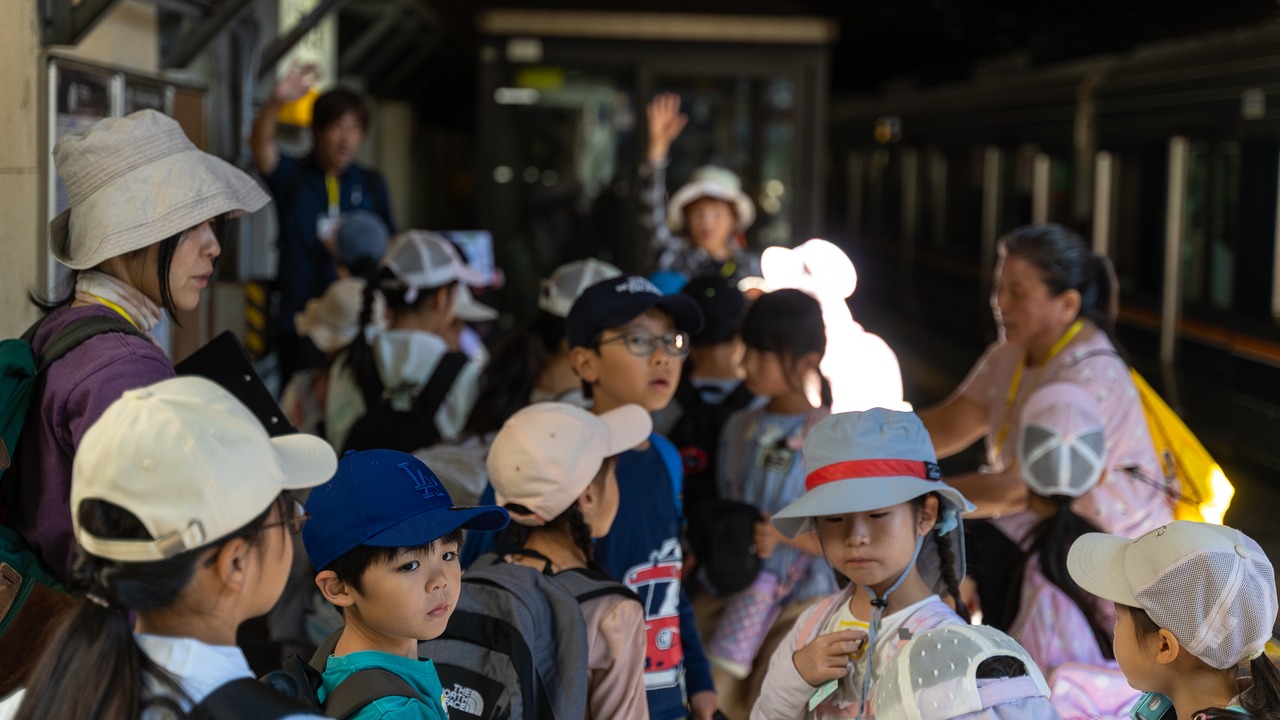 駅ホームで電車を待つ子どもたち
