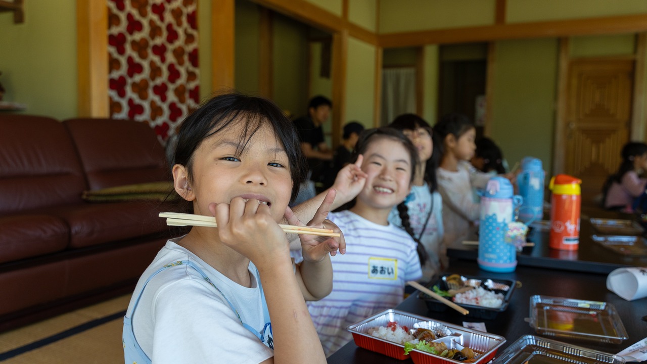 古民家でお弁当を食べる笑顔の子どもたち
