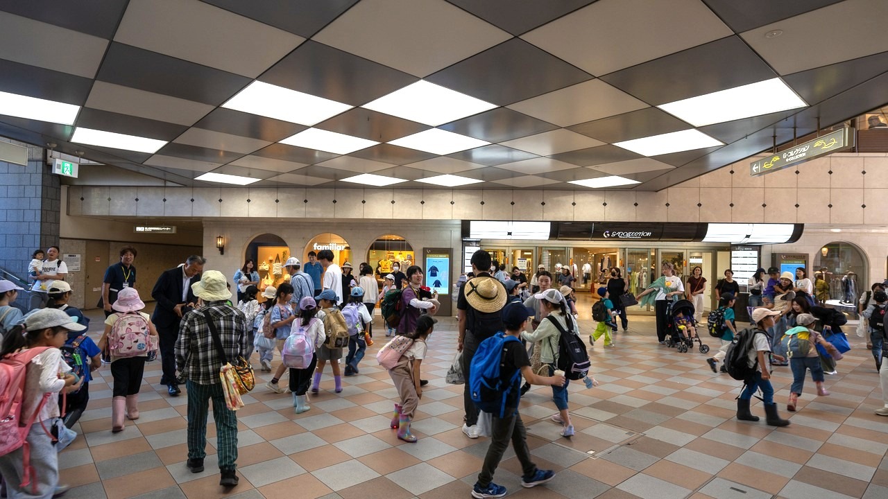 宝塚駅コンコースで家族のお迎えを受ける子どもたち