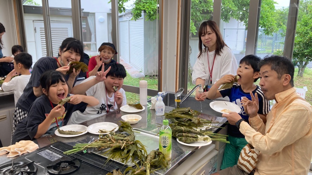西谷ちまきを囲んで笑顔で試食する参加者たち