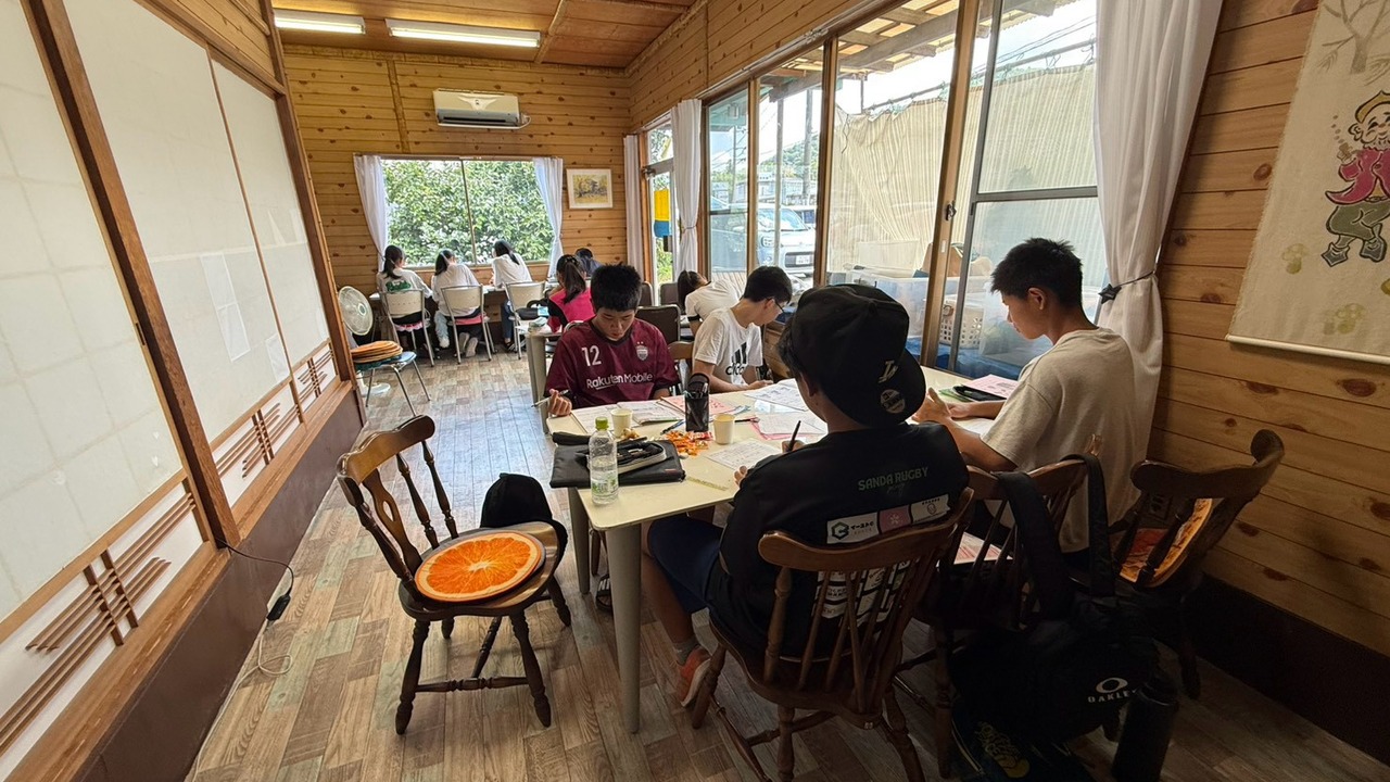 山里の座敷で長机を囲み宿題に取り組む子どもたち