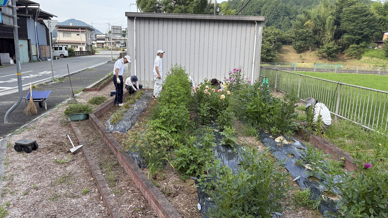 下佐曽利休憩所の花壇で朝の除草作業をする参加者たち