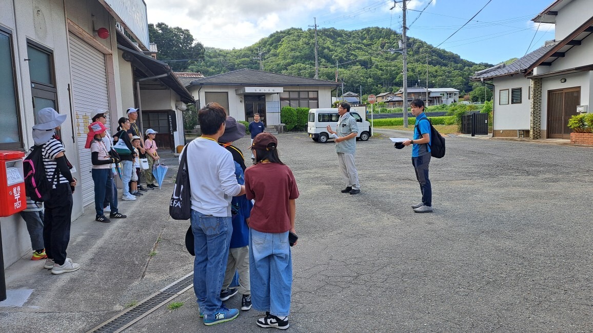 東部公民館前に集まり開会のあいさつを聞く参加者