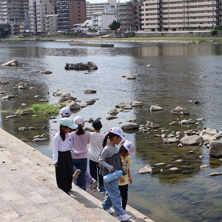 武庫川の河川敷で川をのぞきこむ子どもたち