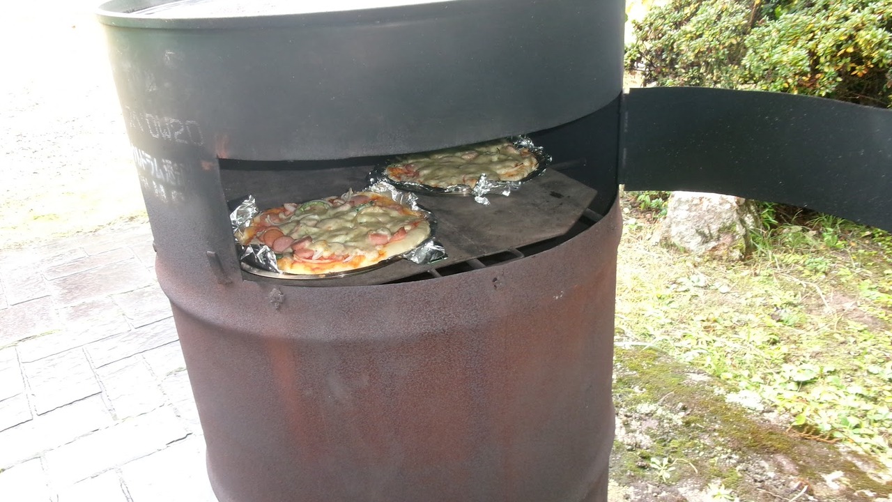 ドラム缶で作った手作りピザ窯で焼かれるピザ
