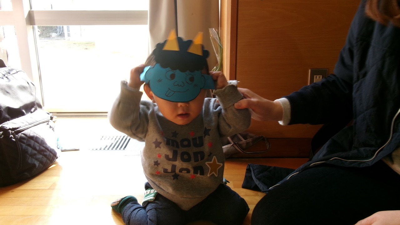 手作りの鬼のお面をつけた小さな子ども