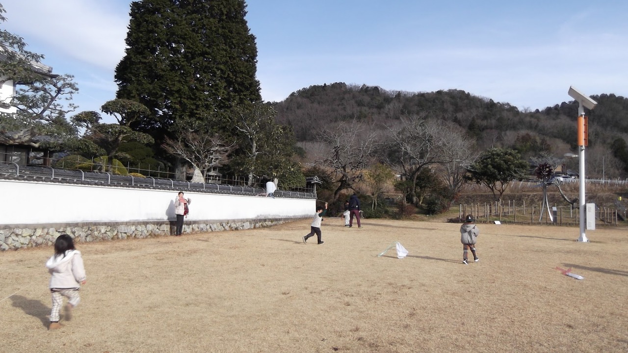 西谷会館の芝生広場で手作りの凧を揚げる子どもたち