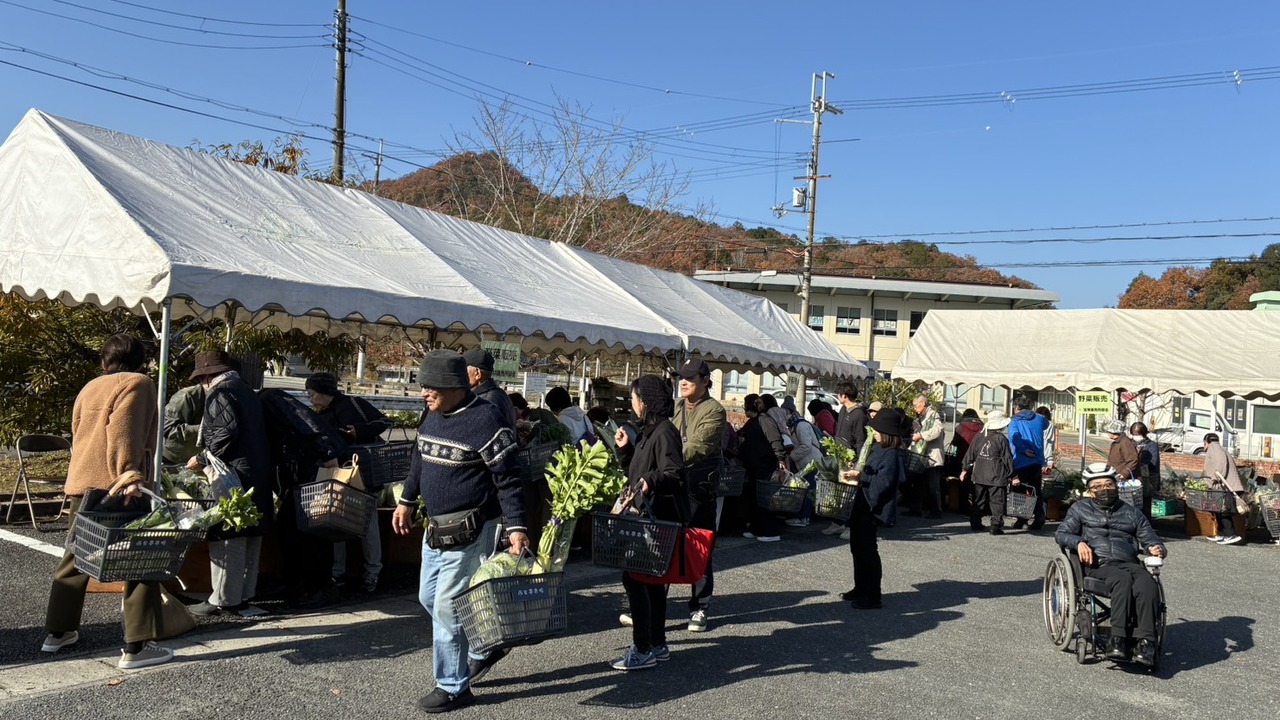 西谷ふれあい夢プラザのテント売り場に、野菜を手にした来場者が集まる収穫祭の様子